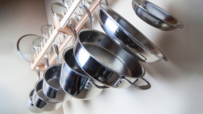 seven saucepans hanging on a rack